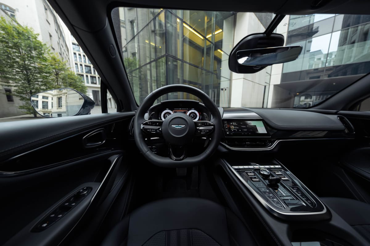 Aston Martin DBX707 interior in Brussels, showcasing the driver-focused cockpit, steering wheel, and centre console.